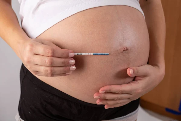 Test de grossesse positif dans les mains de la femme gros plan — Photo