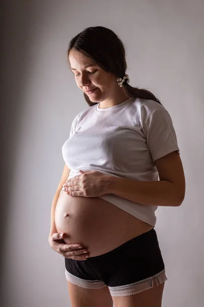 Mulher grávida tocando barriga close-up em um estúdio — Fotografia de Stock