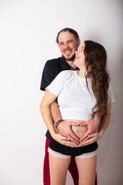 Güzel bir hamile kadın ve yakışıklı kocası karın sarılma kırpılmış görüntü