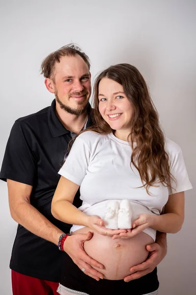 Imagem cortada de mulher grávida bonita e seu marido bonito abraçando a barriga — Fotografia de Stock