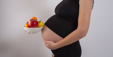 Hamilelik ve sağlıklı organik beslenme. Hamile kadın taze vitamin meyveleri ve boş yer tutuyor. Mesaj için yer. Beklenti ve sağlık kavramı.