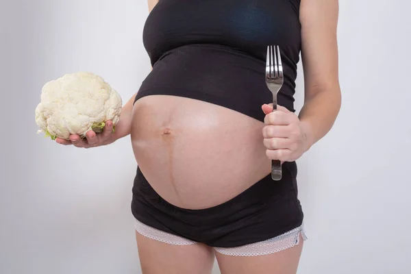 Kobieta w ciąży trzyma świeżą sałatkę w studio — Zdjęcie stockowe