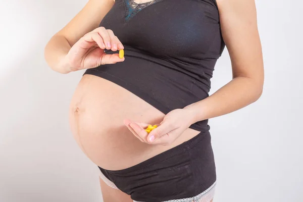 Embarazo, personas y concepto de atención médica - primer plano de la mujer embarazada. vitaminas y minerales para mujeres embarazadas. Tomar medicamentos durante el embarazo. Resfriados y embarazo. Medicamentos para mujeres embarazadas — Foto de Stock