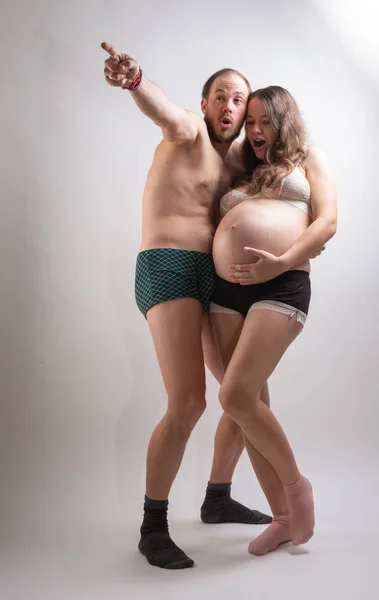 Hermosa mujer embarazada y su marido guapo se besan mientras pasan tiempo juntos en la cama . —  Fotos de Stock