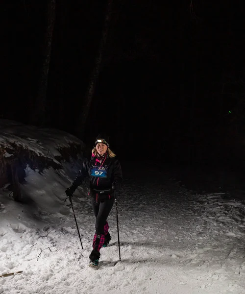 ALMATY KAZAKHSTAN: FEBRUARY 15 2020: Unidentified girls run at night in the winter in the mountains near the city of Almaty with flashlights during the night run of TunRun Limited on February 15, 2020 — Stock Photo, Image
