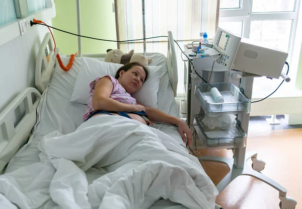Ciężarna kobieta odczuwa silny skurcz w szpitalnej sali porodowej. Koncepcja zdjęcia ciąży, kobiety w ciąży, noworodka i dziecka. — Zdjęcie stockowe