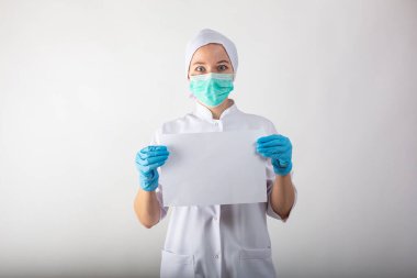 Kadın doktorun ellerinde beyaz çarşaf olan bir pano.