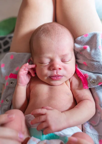 Portakal rengi yastığın üzerinde duran ciddi, sert bir bebek portresi. — Stok fotoğraf