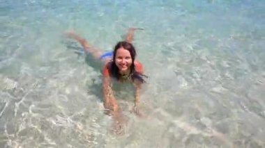 Bali adasındaki mavi okyanusta sığ sularda yüzen güzel kız.