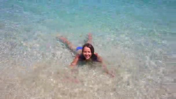 Gyönyörű lány fröcsköl sekély vízben a kék óceánban Bali szigetén. — Stock videók