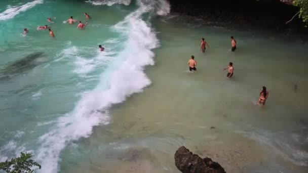 Pessoas felizes salpicando na tempestade. Os homens banham-se no mar com uma forte ventania. As pessoas nadam em ondas grandes . — Vídeo de Stock