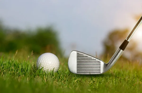 高尔夫俱乐部和高尔夫球在一个美丽的高尔夫球场的绿色草坪上与早晨的阳光 准备在第一个短的时间内上场 世界各地的人在节假日期间为了健康而进行的体育运动 — 图库照片