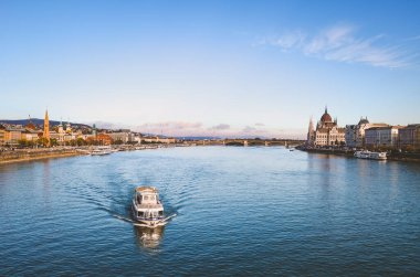 Macaristan 'ın Budapeşte kentindeki Tuna Nehri' nde su üstünde yüzen bir gezi teknesi var. Nehrin iki yakasında da tarihi merkez var. Arkadaki Macar Parlamentosu binası. Budapeşte şehir manzarası