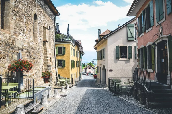 Saint Saphorin, İsviçre - 9 Temmuz 2019: İsviçre Lavaux şarap bölgesindeki St. Saphorin adlı şarap imalathanesinin tarihi caddesi. Geleneksel evler, kaldırımlı sokaklar. Açık hava restoranları