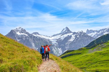 Grindelwald, İsviçre - 16 Ağustos 2019: Yaz Alp manzarası. Kadın yürüyüşçüler ve arka planda İsviçre Alpleri. Grindelwald 'dan Bachalpsee' ye giderken çekilmiş.