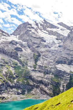 İsviçre 'de Kandersteg yakınlarında Oeschinensee Gölü' nde. Turkuaz göl sarp dağlar ve kayalarla çevrili. İsviçre Alpleri 'nin popüler turistik merkezi. İsviçre yaz mevsiminde