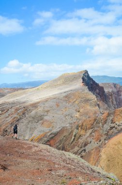 Ponta de Sao Lourenco, Madeira, Portekiz - 12 Şubat 2019: Atlas Okyanusu 'ndaki Portekiz adasındaki volkanik manzara ve kayalar. Yürüyüşçü uçurumun kenarında duruyor. Turizm beldeleri
