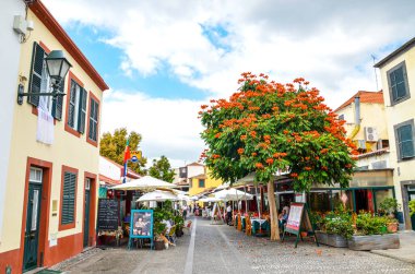 Funchal, Madeira, Portekiz - Sep 10, 2019: Tipik restoran ve kafeleri olan Madeiran başkentinde sokak. İnsanlar dışarıda teraslarda yiyip içiyorlar. Koloni mimarisi. Tarihi eski kasaba