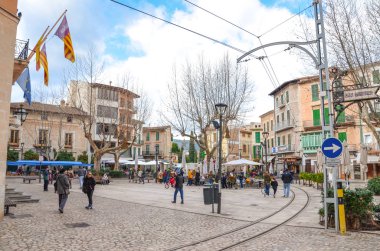 Soller, Mallorca, İspanya - 19 Ocak 2019: İspanya 'nın tarihi merkezi Anayasa Meydanı. Arka planda açık hava restoranlarının önünden geçen insanlar var. Kış mevsimi