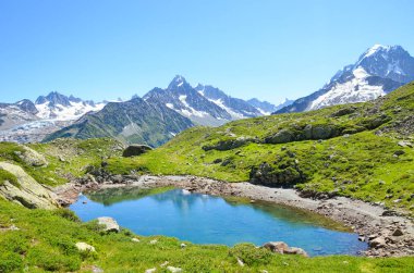 Cheserys Buzulu, Chamonix-Mont-Blanc yakınlarındaki Cheserys Gölü Fransız Alpleri. Arkasında karla kaplı dağlar olan Alp Gölü. Mont Blanc turu. Yaz mevsiminde Alpler