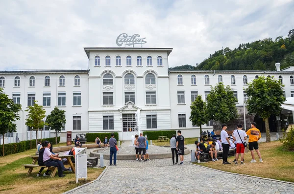 Broc, Svájc - 2019. július 27.: A híres Cailler csokoládégyár épülete előtt várakozó látogatók. Emberek az udvar a areal. Turné és múzeum. Svájci csokoládé — Stock Fotó