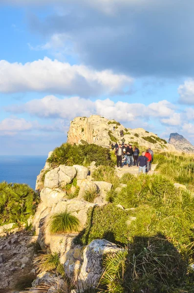 Mirador Es Colomer, Mallorca, Spain - Jan 19, 2019: People walking on a popular viewpoint on the cliffs in Cap de Formentor during winter. Tourists on a trail on the rocks surrounded by Mediterranean — 스톡 사진