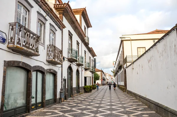 Ponta Delgada, Azorerna, Portugal - 12 jan 2020: Cobbled street in the historical centre of the Portuguese city. Traditionella hus med vita fasader. Människor som går på gatorna — Stockfoto