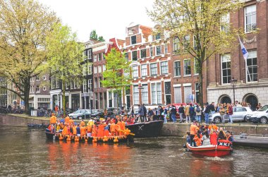 Amsterdam, Hollanda - 27 Nisan 2019: Hollanda Kralı Willem-Alexander 'ın doğum günü olan Koningsdag, Krallar Günü' nü kutlarken ulusal turuncu renkli parti teknelerinde insanlar