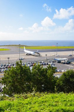 Ponta Delgada, Azores, Portekiz - 14 Ocak 2020: Sao Miguel Adası 'ndaki Joao Paulo Ii Havaalanı. Uçağı olan bir pist, terminal binası ve kiralık arabalar için park yeri. Arkaplanda okyanus