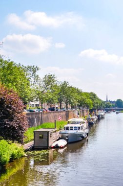 Hertogenbosch, Kuzey Brabant, Hollanda - 9 Haziran 2018: Hollanda 'nın tarihi merkezinde tekneli su kanalı. Ağaçlar ve binalarla çevrili bir kanal. Dikey fotoğraf