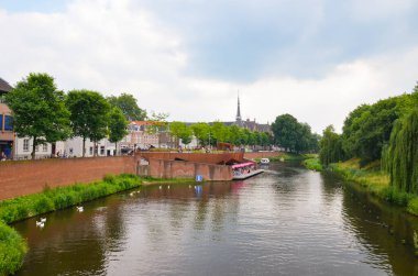 Hertogenbosch, Kuzey Brabant, Hollanda - 9 Haziran 2018: Hollanda 'nın tarihi merkezinde su kanalı. Arka planda tarihi binalar var. Yeşil ağaçlarla çevrili bir kanal.