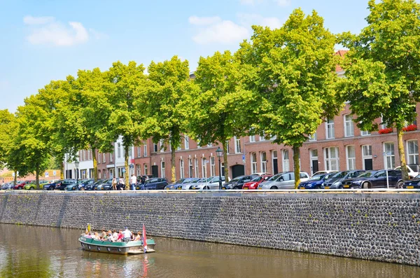 Hertogenbosch, Brabant-Septentrional, Pays-Bas - 9 juin 2018 : Canal d'eau avec bateau touristique dans le centre historique de la ville néerlandaise. Canal entouré d'arbres, de bâtiments et de voitures garées — Photo