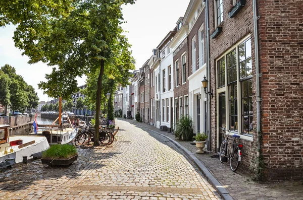 Hertogenbosch, Brabant-Septentrional, Pays-Bas - 9 juin 2018 : Rue le long du canal d'eau avec des bateaux dans le centre historique de la ville néerlandaise. Arbres verts et vélos dans la rue — Photo