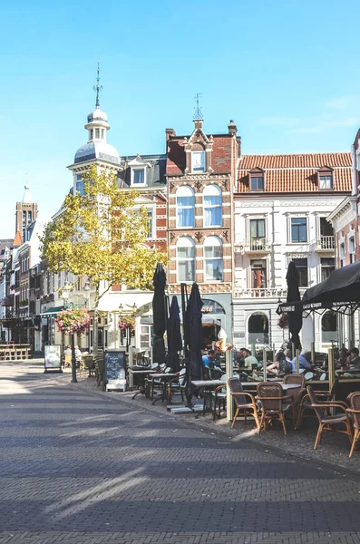 Venlo, Limbourg, Pays-Bas - 13 octobre 2018 : Rue avec cafés, restaurants et bars dans le centre historique de la ville néerlandaise. Des gens assis dans les jardins extérieurs. Photo verticale — Photo
