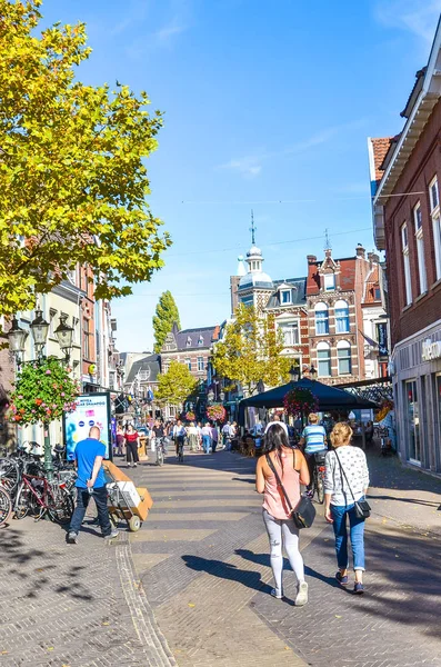 Venlo, Limburg, Hollandia - 2018. október 13.: Bevásárlóutca a holland város történelmi központjában. Az utcán sétáló emberek, a történelmi tér a háttérben. Függőleges fénykép — Stock Fotó