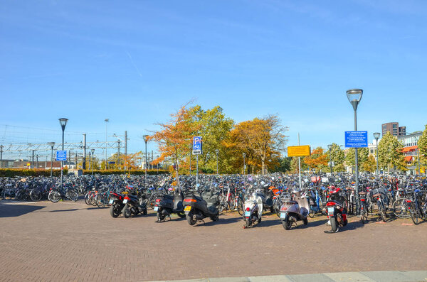 Венло, Лимбург, Нидерланды - 13 октября 2018 года: Рощи припаркованных велосипедов и мотоциклов в голландском городе рядом с центральным железнодорожным вокзалом. Городской велосипед. Экологичные транспортные средства
.