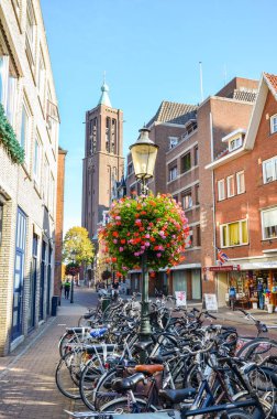 Venlo, Limburg, Hollanda - 13 Ekim 2018: Hollanda 'nın tarihi merkezinde alışveriş caddesi. Ön planda park etmiş bisikletler. Sokakta yürüyen insanlar. Arka planda kule.