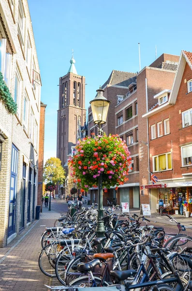 Venlo, Limburg, Hollanda - 13 Ekim 2018: Hollanda 'nın tarihi merkezinde alışveriş caddesi. Ön planda park etmiş bisikletler. Sokakta yürüyen insanlar. Arka planda kule.
