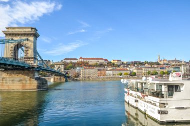 Budapeşte, Macaristan - 6 Kasım 2019: Macar başkentinde Tuna Nehri, turist yolcu gemisinin bir kısmıyla birlikte. Şehrin en uzak arkaplandaki tarihi merkezi. Szechenyi Zincir Köprüsü solda..