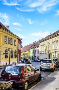 Budapeşte, Macaristan - 6 Kasım 2019: Tarihi merkezde renkli evleri olan güzel tarihi cadde. Arabaları kaldırım kenarına park ettim. Macar başkentinin eski bir kasabası. Dikey fotoğraf.