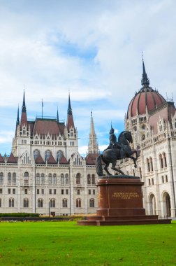 Budapeşte, Macaristan - 6 Kasım 2019: Orszaghaz Macar Parlamentosu binası. Macaristan Ulusal Meclisi 'nin merkezi. Ferenc Rakoczi II 'nin binicilik heykeli ve ön planda yeşil çimenler.