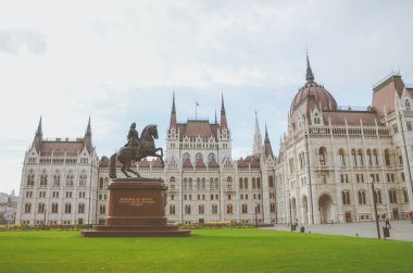 Budapeşte, Macaristan - 6 Kasım 2019: Orszaghaz Macar Parlamentosu binası. Macaristan Ulusal Meclisi 'nin merkezi. Ferenc Rakoczi II 'nin binicilik heykeli. Filtreli yatay fotoğraf.