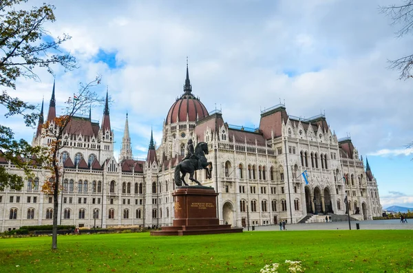 Budapeşte, Macaristan - 6 Kasım 2019: Orszaghaz Macar Parlamentosu binası. Macaristan Ulusal Meclisi 'nin merkezi. Ferenc Rakoczi II 'nin binicilik heykeli ve ön planda yeşil çimenler.