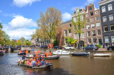 Amsterdam, Hollanda - 27 Nisan 2019: Hollanda Kralı Willem-Alexander 'ın doğum günü olan Koningsdag, Krallar Günü' nü kutlarken ulusal turuncu renkli parti teknelerinde insanlar.
