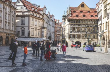 Prag, Çek Cumhuriyeti - 23 Nisan 2020: Eski Şehir Meydanı 'nda ünlü Astronomik Saat Orloj tarafından tıbbi maske takan insanlar. Koronavirüs salgını sırasında şehir merkezi. COVID-19 krizi.