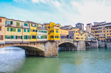 Ünlü Ponte Vecchio Köprüsü, Floransa, Toskana, İtalya 'daki Arno Nehri üzerindeki ortaçağ taş köprüsü. İtalyan şehrinin büyük simgesi. İnşaattaki renkli evler. Yatay fotoğraf.
