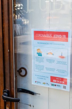 Faro, Portekiz - 16 Mart 2020: Portekizce ve İngilizce Coronavirus Güvenlik Talimatları broşürü ile restoranın kapalı ön kapısı. Restoranlar COVID-19 salgını nedeniyle kapatıldı.