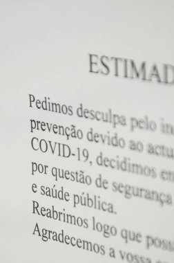 Faro, Portekiz - 16 Mart 2020: Portekizce yazılmış bir dükkanın ön camına basılmış bir mesaj, Coronavirus, COVID-19 salgını nedeniyle kapanış hakkında insanları bilgilendiriyor. SARS-CoV-2 salgını.