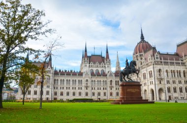 Budapeşte, Macaristan - 6 Kasım 2019: Orszaghaz Macar Parlamentosu binası. Macaristan Ulusal Meclisi 'nin merkezi. Ferenc Rakoczi II 'nin binicilik heykeli ve ön planda yeşil çimenler.