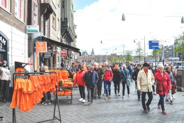Amsterdam, Hollanda - 27 Nisan 2019: Hollanda başkenti Koningsdag 'ın Kings Günü' nde turuncu t-shirtlerle ayakta duruyor. Sokakta yürüyen insanlar. Merkezde kalabalık sokaklar var..